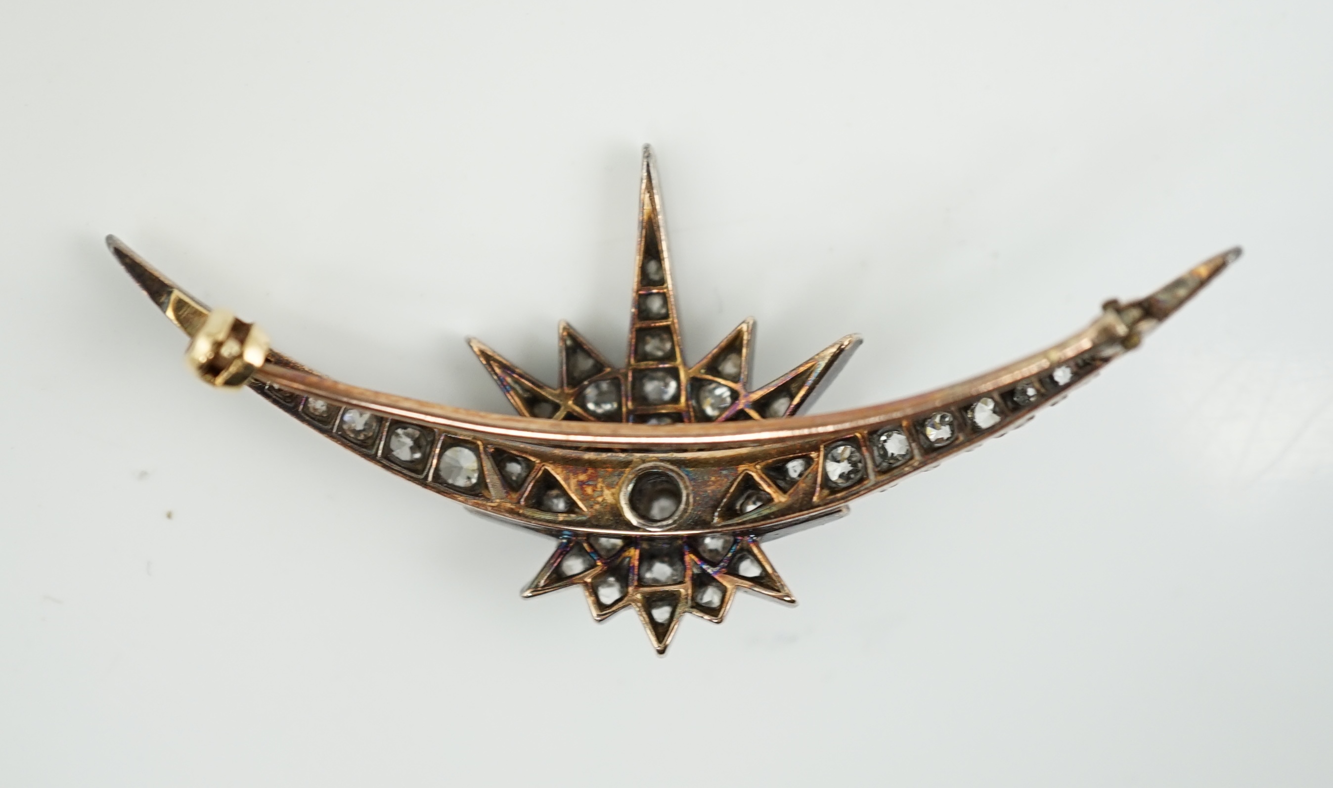 A Victorian gold, silver and graduated diamond cluster set crescent and starburst brooch